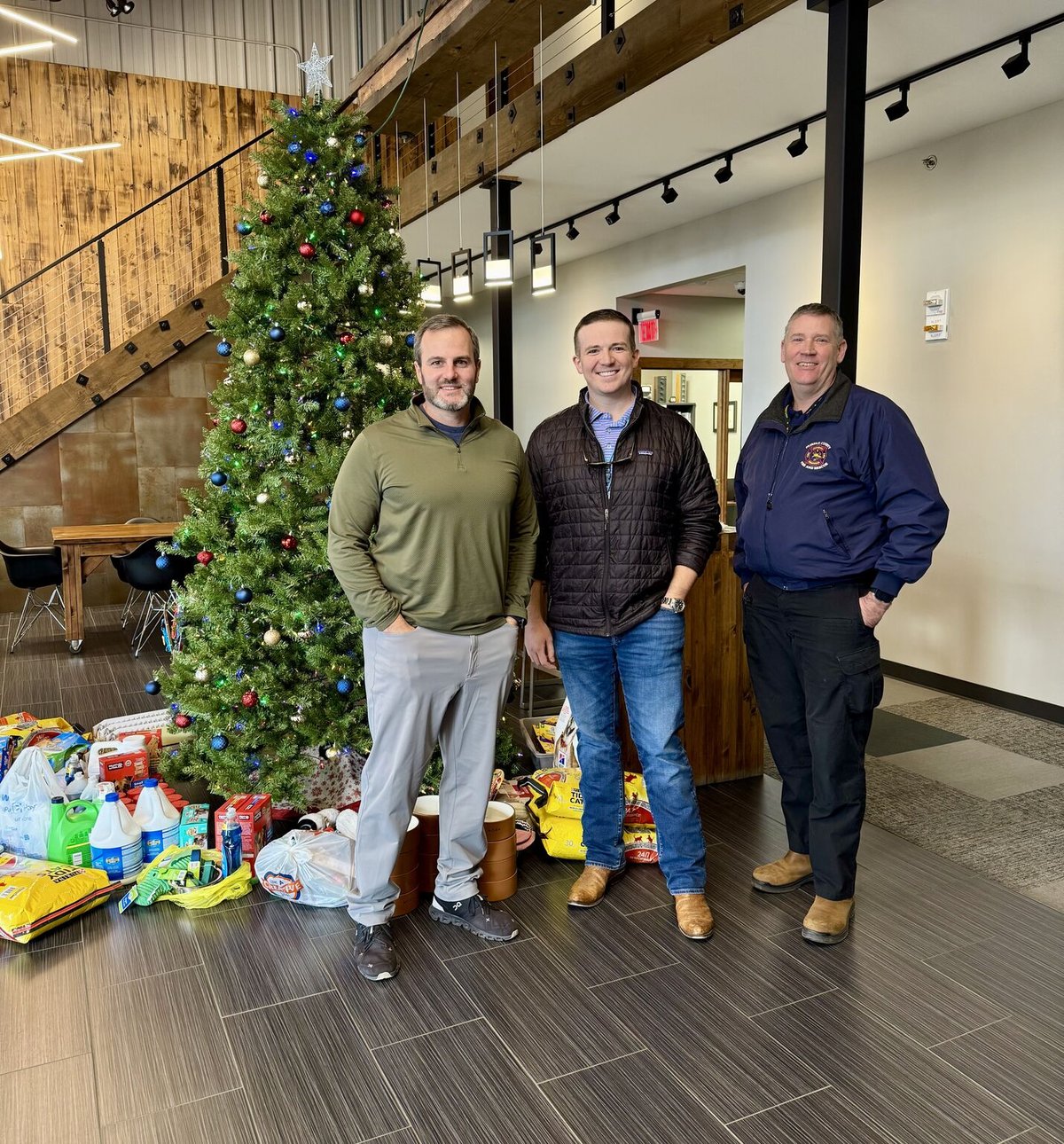 Donated pet food, toys, and supplies placed under a Christmas tree by Hyperion employees before delivery